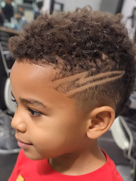 Kids Frohawk Fade & Temple Razor Slash - Fun youth natural coil frohawk with low skin fade and dual carved temple razor lines.